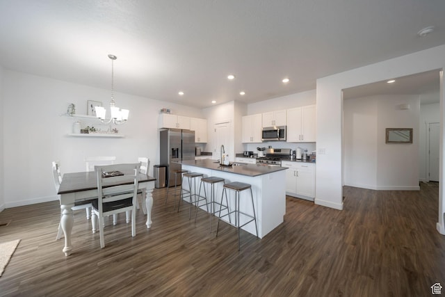 14837 S Messi St, Herriman, UT 84096 - kitchen with appliances with stainless steel finishes, dark countertops, a chandelier, dark wood finished floors, and white cabinetry