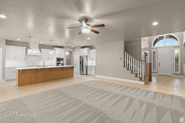 2762 E Hazel Dr, St George, UT 84790 - kitchen featuring appliances with stainless steel finishes, open floor plan, light wood-style floors, a large island, and ceiling fan