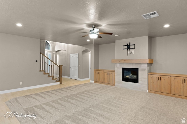2762 E Hazel Dr, St George, UT 84790 - unfurnished living room with arched walkways, ceiling fan, a fireplace, recessed lighting, and stairway