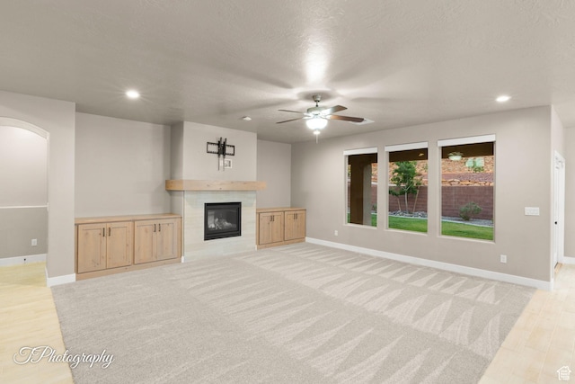 2762 E Hazel Dr, St George, UT 84790 - unfurnished living room with ceiling fan, arched walkways, a tile fireplace, and recessed lighting
