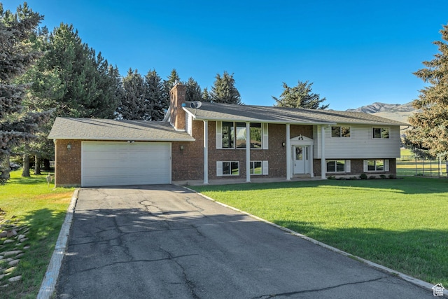 4918 E 2800 N, Eden, UT 84310 - raised ranch with asphalt driveway, a front lawn, and brick siding