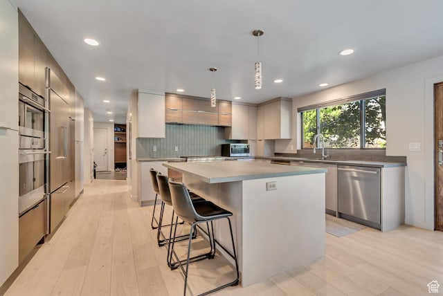 22 S Sunwood Ln, Sandy, UT 84092 - kitchen with appliances with stainless steel finishes, modern cabinets, light wood finished floors, tasteful backsplash, and recessed lighting