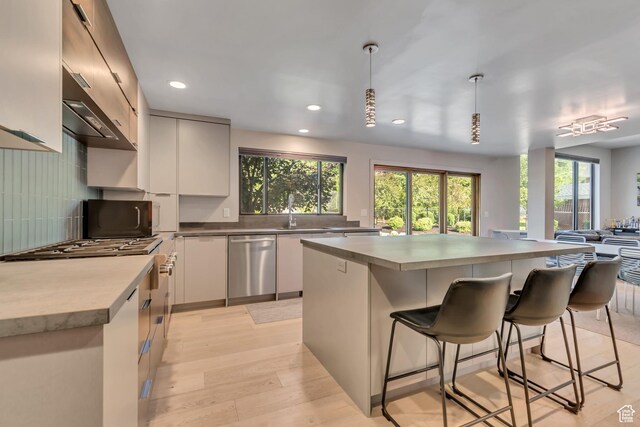 22 S Sunwood Ln, Sandy, UT 84092 - kitchen featuring dishwasher, a breakfast bar area, light wood-type flooring, recessed lighting, and decorative backsplash