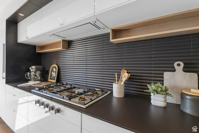 4352 S Zarahemla Dr, Salt Lake City, UT 84124 - kitchen featuring stainless steel gas cooktop, open shelves, white cabinets, dark countertops, and decorative backsplash