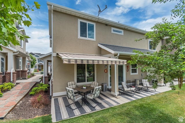 11874 S Rushmore Park Ln W, Herriman, UT 84096 - back of property with stucco siding, a standing seam roof, a metal roof, a patio area, and a lawn