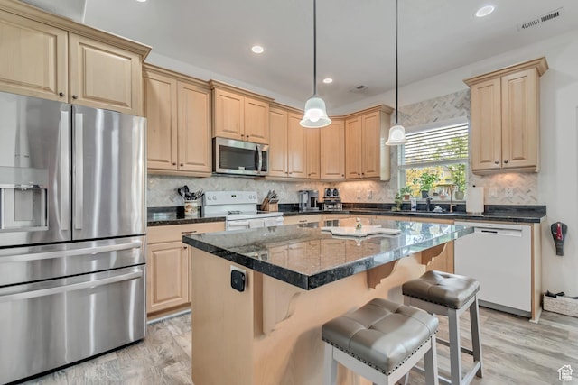 11874 S Rushmore Park Ln W, Herriman, UT 84096 - kitchen with stainless steel appliances, light brown cabinets, light wood-style flooring, a kitchen island, and backsplash