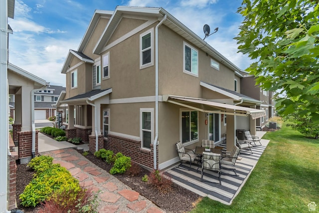 11874 S Rushmore Park Ln W, Herriman, UT 84096 - view of side of home featuring a yard, stucco siding, brick siding, and a patio