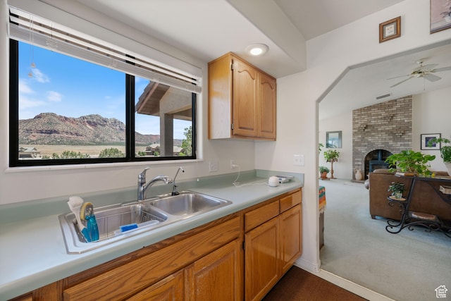 1387 N Mount Zion Dr, Apple Valley, UT 84737 - kitchen featuring dark carpet, light countertops, a ceiling fan, a fireplace, and open floor plan