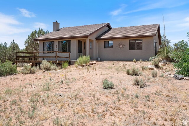 1387 N Mount Zion Dr, Apple Valley, UT 84737 - view of front of home with a chimney, a tiled roof, and stucco siding