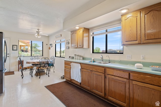 1387 N Mount Zion Dr, Apple Valley, UT 84737 - kitchen featuring light countertops, ceiling fan, brown cabinets, freestanding refrigerator, and light flooring