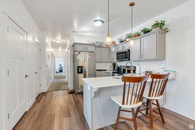 1831 W Newcastle Ln Unit 101, Saratoga Springs, UT 84045 - kitchen featuring stainless steel appliances, light wood-style flooring, a peninsula, and gray cabinetry