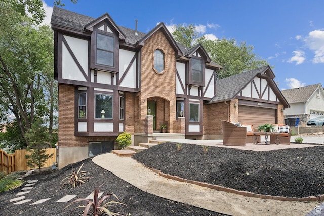 2255 E Camino Way Way S, Cottonwood Heights, UT 84121 - tudor-style house featuring brick siding, an attached garage, a shingled roof, and stucco siding
