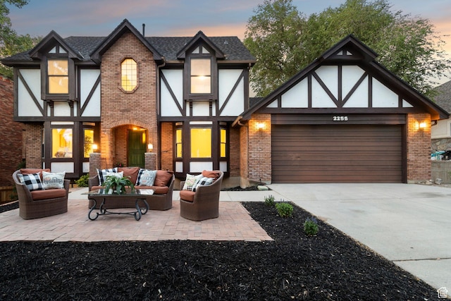 2255 E Camino Way Way S, Cottonwood Heights, UT 84121 - view of front facade with outdoor lounge area, brick siding, concrete driveway, an attached garage, and a shingled roof