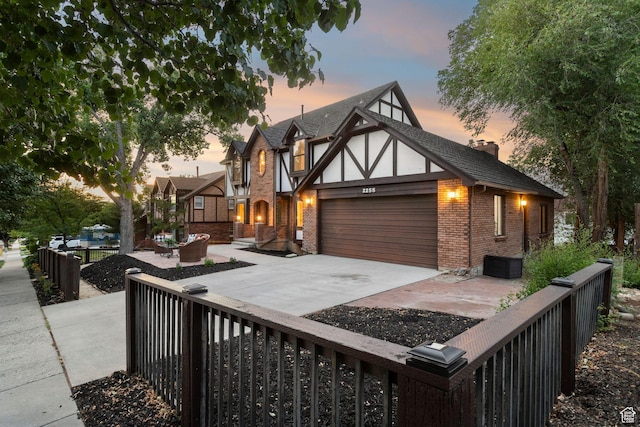 2255 E Camino Way Way S, Cottonwood Heights, UT 84121 - english style home with brick siding, a garage, concrete driveway, and a chimney