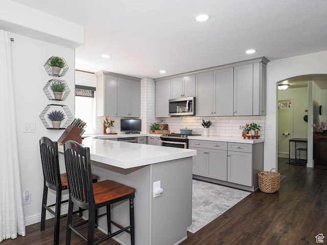 1152 E Gavin Cir, Draper, UT 84020 - kitchen featuring gray cabinets, stainless steel appliances, a breakfast bar area, arched walkways, and recessed lighting