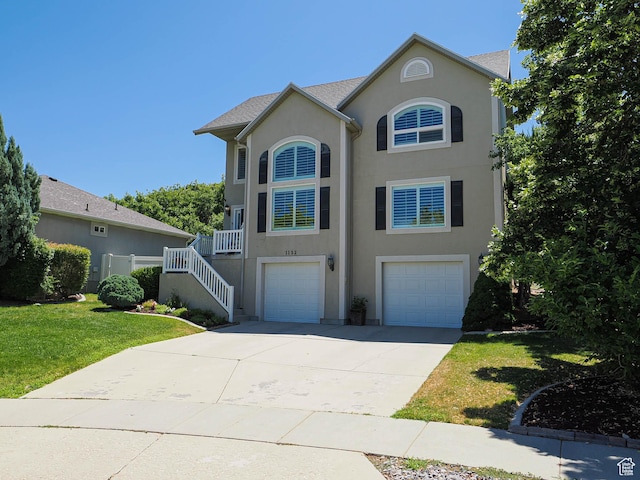 1152 E Gavin Cir, Draper, UT 84020 - view of front facade featuring an attached garage, stucco siding, a front lawn, concrete driveway, and stairway