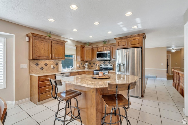 421 S 1400 E, Fruit Heights, UT 84037 - kitchen featuring appliances with stainless steel finishes, light tile patterned floors, decorative backsplash, a center island, and recessed lighting