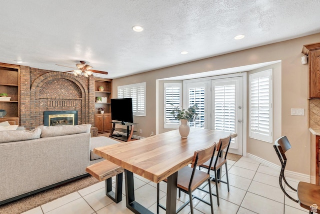 421 S 1400 E, Fruit Heights, UT 84037 - dining space featuring ceiling fan, a fireplace, a textured ceiling, light tile patterned floors, and built in shelves