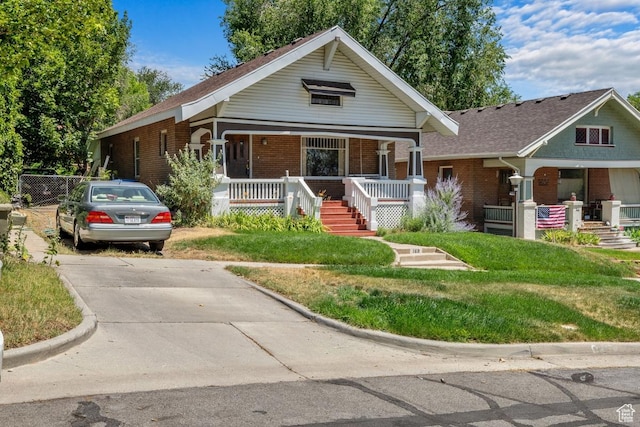 168 N T St E, Salt Lake City, UT 84103 - view of front facade with a porch, brick siding, and a front lawn