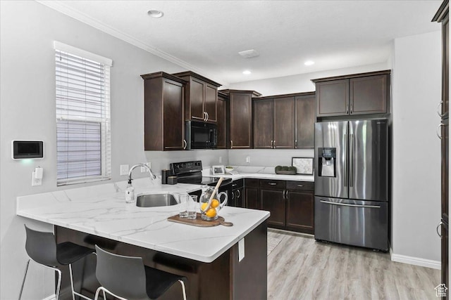 4988 W Currant Dr, South Jordan, UT 84009 - kitchen featuring black appliances, a peninsula, dark brown cabinets, light wood-style floors, and light stone countertops