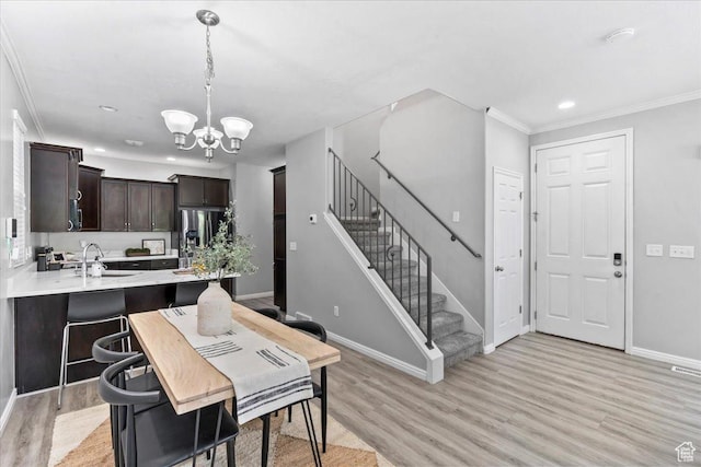 4988 W Currant Dr, South Jordan, UT 84009 - dining room featuring a chandelier, light wood-style flooring, stairs, crown molding, and recessed lighting