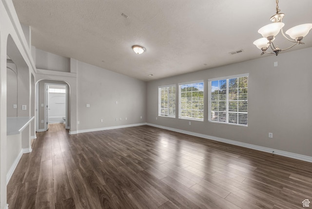 1195 W Dallin Dr Unit 304, Pleasant Grove, UT 84062 - unfurnished room featuring arched walkways, a chandelier, dark wood finished floors, a textured ceiling, and lofted ceiling