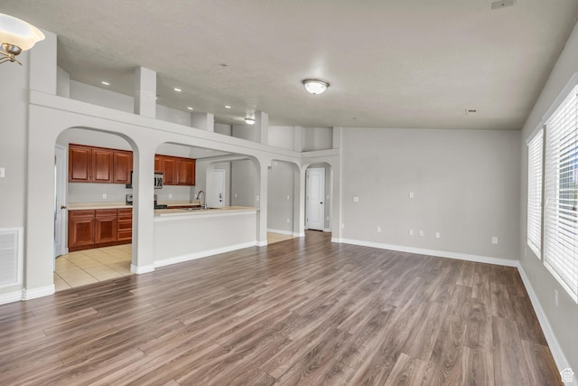 1195 W Dallin Dr Unit 304, Pleasant Grove, UT 84062 - unfurnished living room with arched walkways, light wood finished floors, and recessed lighting
