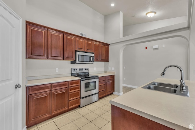 1195 W Dallin Dr Unit 304, Pleasant Grove, UT 84062 - kitchen with appliances with stainless steel finishes, light tile patterned floors, light countertops, and arched walkways