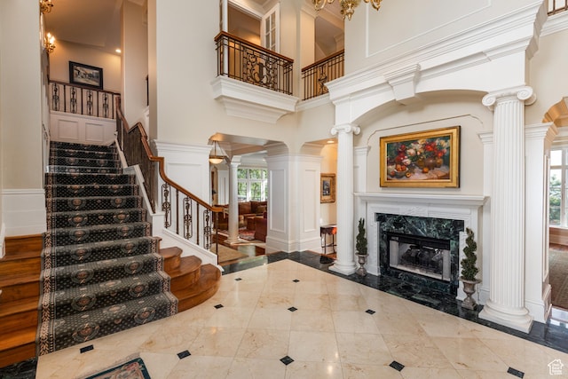 1781 Lorien Dr, Bountiful, UT 84010 - foyer with ornate columns, a decorative wall, inlaid floor details, a towering ceiling, and stairs