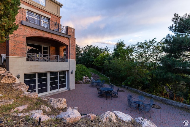 1781 Lorien Dr, Bountiful, UT 84010 - back of property featuring a balcony, a patio, brick siding, and outdoor dining area