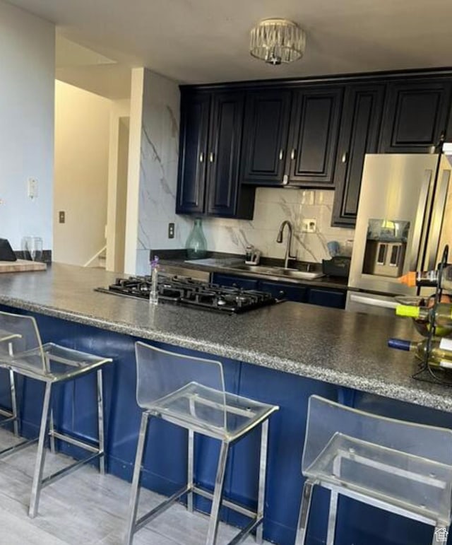 2267 W 4240 S, Taylorsville, UT 84129 - kitchen featuring stainless steel refrigerator with ice dispenser, gas cooktop, a kitchen bar, and dark cabinets