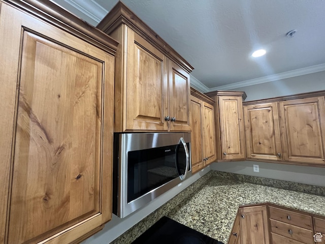 982 W 960 N Unit 101, Orem, UT 84057 - kitchen view of stainless steel microwave, ornamental molding, light stone counters, and brown cabinetry