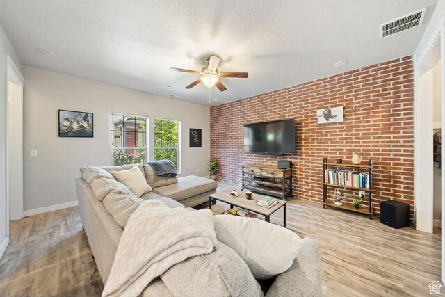 862 W Capraia Ct, Midvale, UT 84047 - living room with a ceiling fan, wood finished floors, brick wall, and a textured ceiling