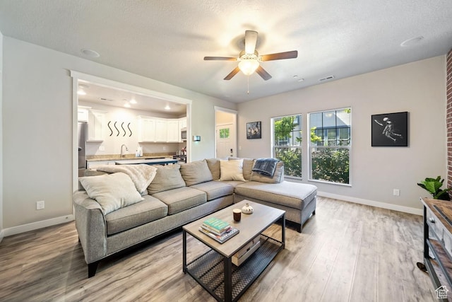 862 W Capraia Ct, Midvale, UT 84047 - living area with a ceiling fan, light wood-style flooring, and a textured ceiling