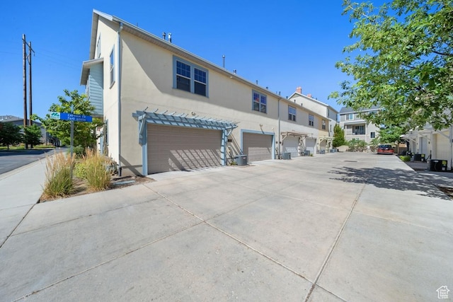 862 W Capraia Ct, Midvale, UT 84047 - rear view of house featuring stucco siding, a garage, driveway, and a residential view