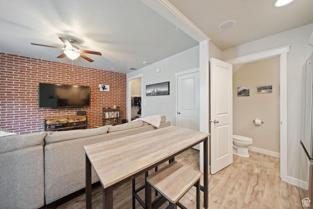 862 W Capraia Ct, Midvale, UT 84047 - living area with ceiling fan, brick wall, and light wood-style floors