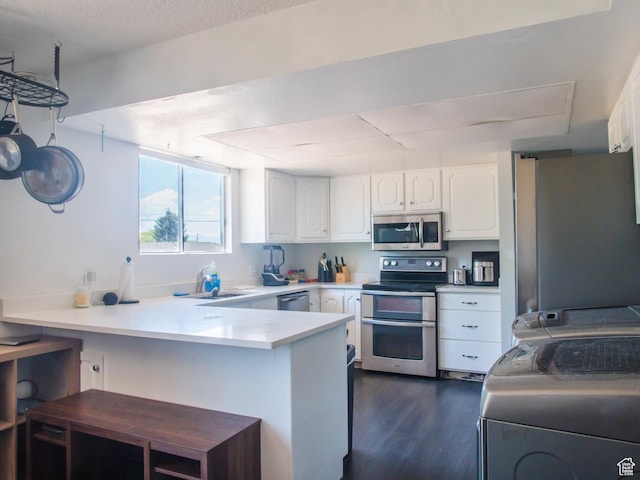 663 N 550 W, Orem, UT 84057 - kitchen featuring appliances with stainless steel finishes, a peninsula, dark wood finished floors, white cabinets, and light countertops