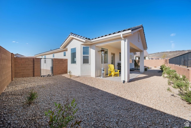 974 N Pleasant Valley Ln, Washington, UT 84780 - rear view of property with stucco siding, a fenced backyard, a patio, and a tiled roof