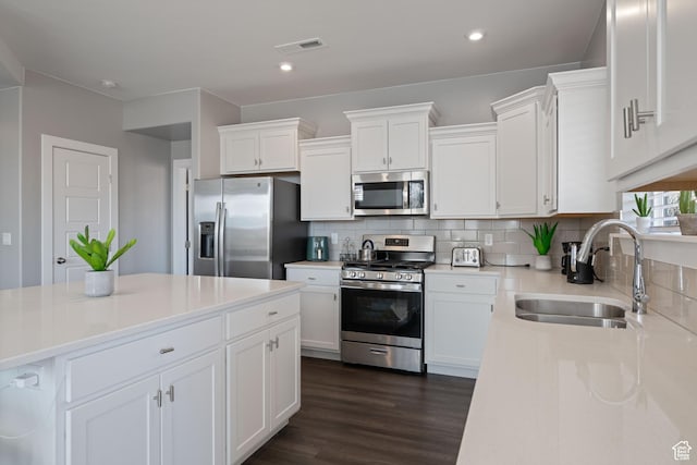 974 N Pleasant Valley Ln, Washington, UT 84780 - kitchen with stainless steel appliances, dark wood-style floors, white cabinets, decorative backsplash, and recessed lighting