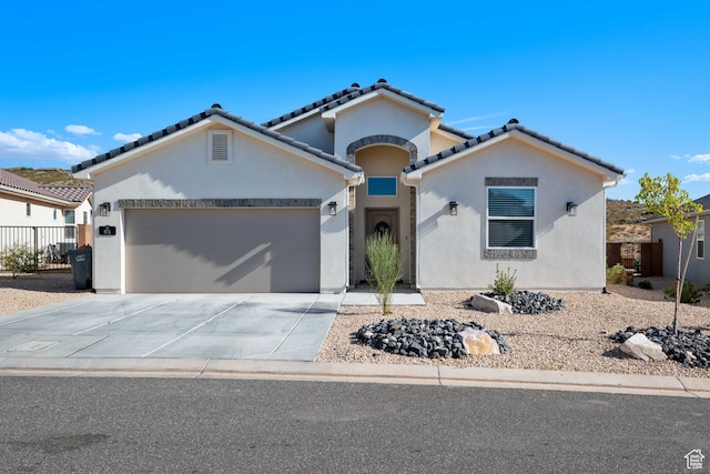 974 N Pleasant Valley Ln, Washington, UT 84780 - mediterranean / spanish house featuring an attached garage, stucco siding, concrete driveway, and a tiled roof