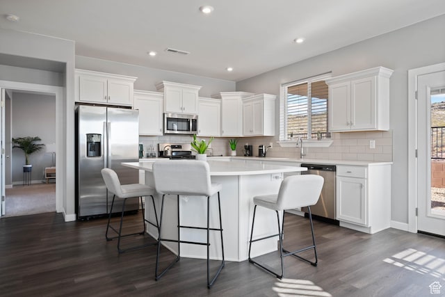 974 N Pleasant Valley Ln, Washington, UT 84780 - kitchen featuring appliances with stainless steel finishes, a kitchen island, dark wood-style floors, tasteful backsplash, and recessed lighting