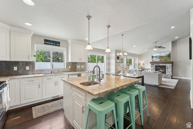 631 S Falkirk Rd, Heber City, UT 84032 - kitchen with ceiling fan, a stone fireplace, backsplash, white cabinets, and light stone countertops