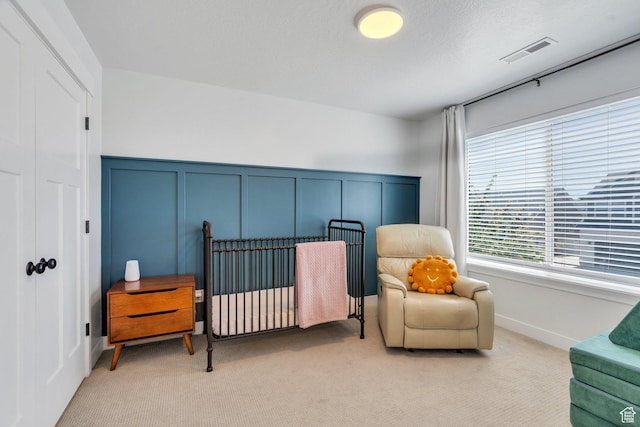 131 N Desert Sage Dr, Saratoga Springs, UT 84045 - bedroom with light carpet, a decorative wall, a closet, and wainscoting