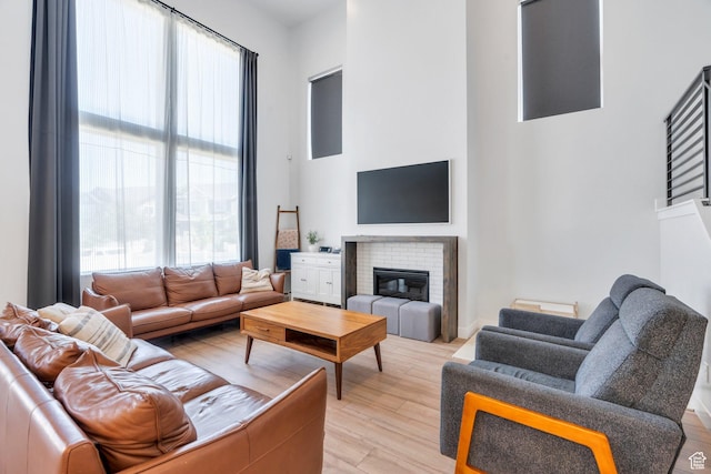 131 N Desert Sage Dr, Saratoga Springs, UT 84045 - living room featuring a towering ceiling, a brick fireplace, and light wood finished floors