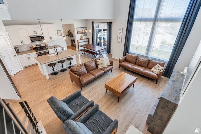 131 N Desert Sage Dr, Saratoga Springs, UT 84045 - living room with light wood-style flooring and a towering ceiling