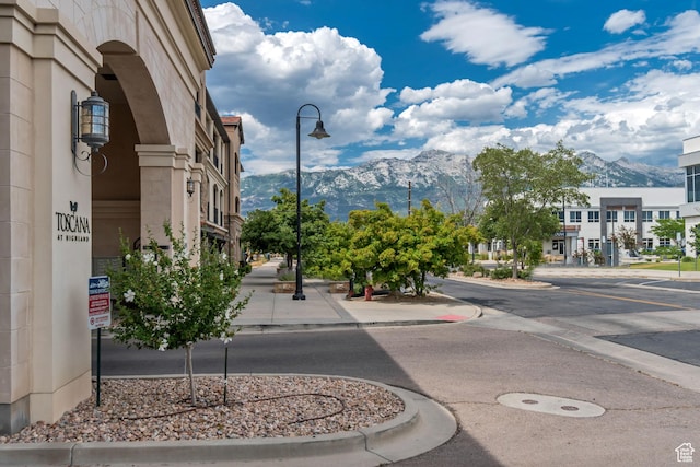 10925 N Marsala Dr, Highland, UT 84003 - view of asphalt road with street lighting, a mountain view, curbs, and sidewalks