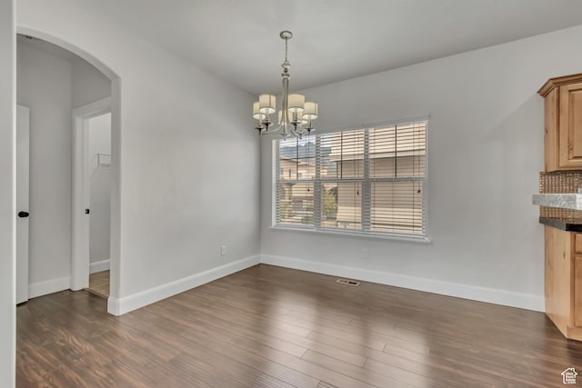 10925 N Marsala Dr, Highland, UT 84003 - unfurnished dining area featuring arched walkways, a chandelier, and dark wood-style flooring