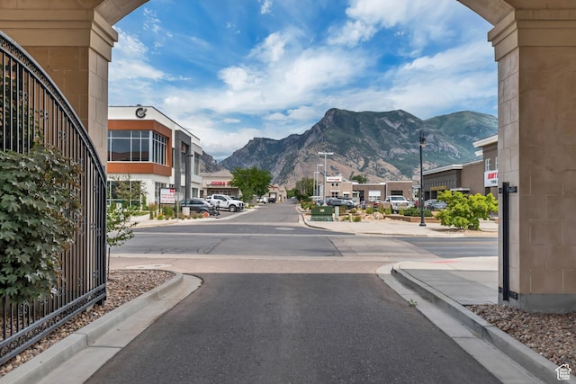10925 N Marsala Dr, Highland, UT 84003 - view of asphalt street featuring a mountain view, curbs, and street lights