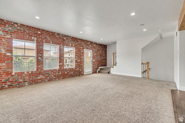 10925 N Marsala Dr, Highland, UT 84003 - unfurnished living room with plenty of natural light, carpet floors, brick wall, recessed lighting, and stairway