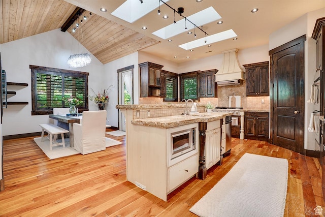 1307 N Dutch Highland Dr, Midway, UT 84049 - kitchen featuring built in microwave, custom range hood, a skylight, light wood finished floors, and recessed lighting